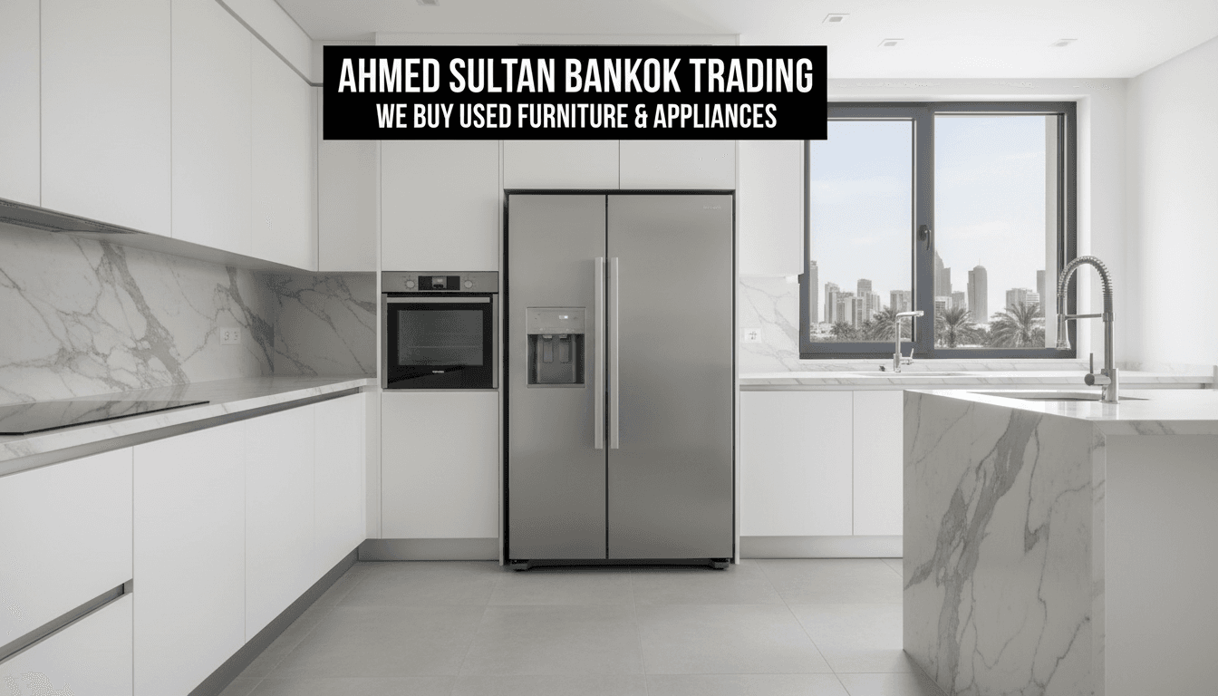 Stainless steel refrigerator standing in modern kitchen with white cabinetry and marble countertops, Doha apartment